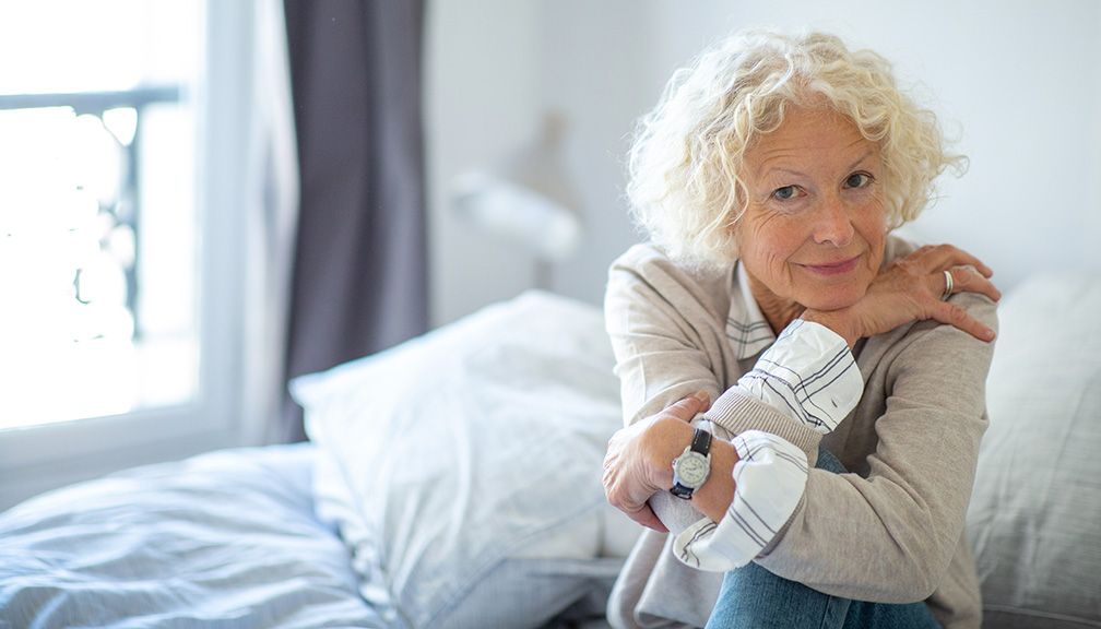 Photo of Woman Sitting by Herself on Bed