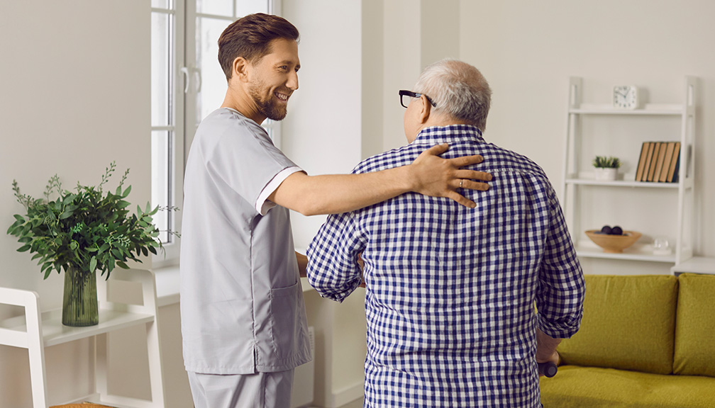 Photo of Male Caregiver Assisting Older Man