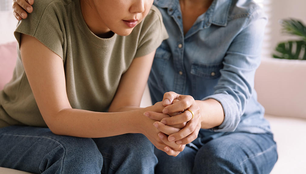 Photo of Parent Sitting With and Reassuring Child