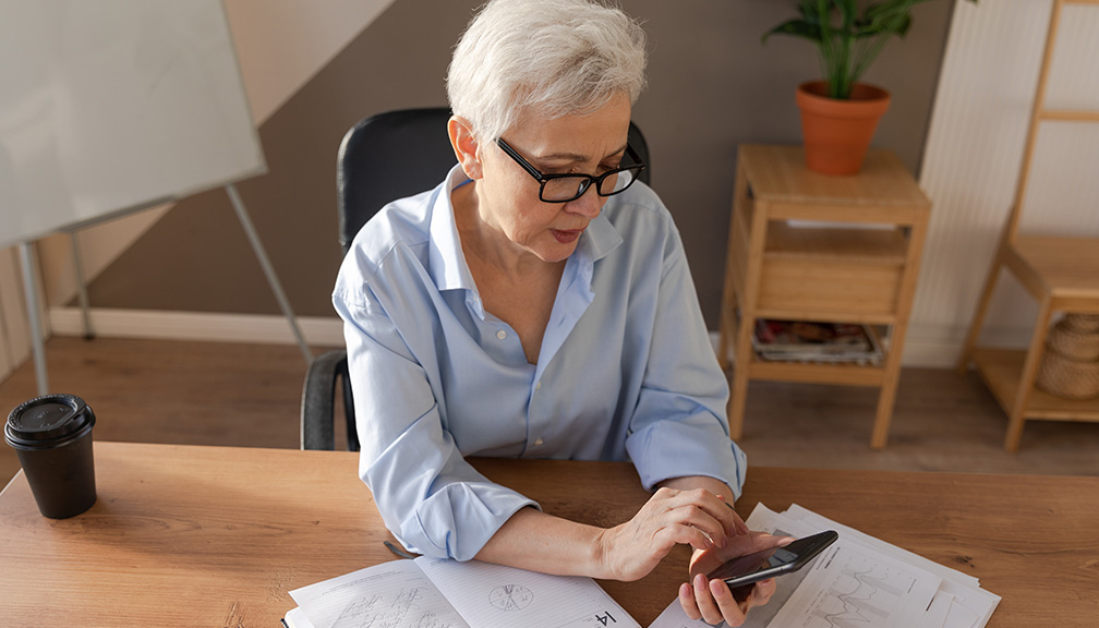 Photo of White-Haired Woman Calculating on Phone